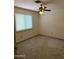 Cozy carpeted bedroom with natural light from a window and ceiling fan at 1813 E Sheena Dr, Phoenix, AZ 85022