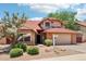Charming home featuring a red tile roof, a two-car garage, and desert landscaping in the front yard at 1813 E Sheena Dr, Phoenix, AZ 85022