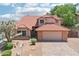 Charming home featuring a red tile roof, a two-car garage, and desert landscaping in the front yard at 1813 E Sheena Dr, Phoenix, AZ 85022