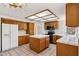 Spacious kitchen with tile flooring, an island, wooden cabinets and modern appliances at 1813 E Sheena Dr, Phoenix, AZ 85022