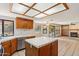 Bright kitchen featuring an island, tile countertops, wooden cabinets and a unique skylight at 1813 E Sheena Dr, Phoenix, AZ 85022