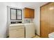 Laundry room with washer, dryer, and wooden cabinets above at 1813 E Sheena Dr, Phoenix, AZ 85022