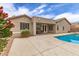 Back exterior view of house with a covered patio, backyard swimming pool, desert landscaping, and privacy wall at 18614 E Oriole Way, Queen Creek, AZ 85142