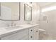 Modern bathroom featuring double sinks, white cabinetry, decorative mirrors and walk-in shower with white tiling at 18614 E Oriole Way, Queen Creek, AZ 85142