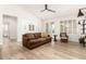 Bright living room boasts hardwood floors, a ceiling fan, and a large brown leather sofa at 18614 E Oriole Way, Queen Creek, AZ 85142