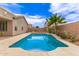 Backyard view of in-ground pool with desert landscaping, exterior of the house and privacy wall at 18614 E Oriole Way, Queen Creek, AZ 85142