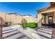 Backyard showcasing artificial turf, stone pavers, a barbecue grill, and a small tree at 20496 W Valley View Dr, Buckeye, AZ 85396