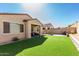 Expansive backyard featuring artificial turf, a covered patio, and block wall for outdoor enjoyment at 20496 W Valley View Dr, Buckeye, AZ 85396