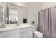 Bathroom showcasing a white vanity, large mirror, decorative accents, and a shower with a patterned curtain at 20496 W Valley View Dr, Buckeye, AZ 85396
