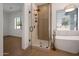 Modern bathroom showcasing a glass-enclosed shower and soaking tub, with neutral tile and gold fixtures at 20823 S 185Th Way, Queen Creek, AZ 85142