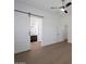 Spacious main bedroom with a barn door leading to the en suite bathroom, wood floors, and a ceiling fan at 20823 S 185Th Way, Queen Creek, AZ 85142