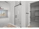 Bright bathroom featuring a glass shower and walk-in closet with shelving for organization at 23036 E Oriole Way, Queen Creek, AZ 85142