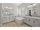 A bright and spacious bathroom boasts dual vanities, a soaking tub, and tiled floors at 23036 E Oriole Way, Queen Creek, AZ 85142