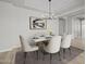 Elegant dining room with modern chandelier and artwork, marble table, and neutral chairs at 23036 E Oriole Way, Queen Creek, AZ 85142
