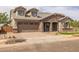 Charming two-story home with stone accents, three-car garage, and well-manicured landscaping at 23036 E Oriole Way, Queen Creek, AZ 85142