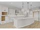 An open kitchen with white cabinets, a large island, pendant lighting, and modern stainless steel appliances at 23036 E Oriole Way, Queen Creek, AZ 85142