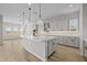 Modern kitchen with an oversized island, decorative pendant lighting, and shaker style cabinetry at 23036 E Oriole Way, Queen Creek, AZ 85142