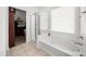 Clean bathroom featuring a soaking tub under a window and a glass enclosed shower at 23690 W Ripple Rd, Buckeye, AZ 85326