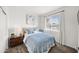 Cozy bedroom with a queen-size bed, stylish blue quilt, and a large window with a view at 23690 W Ripple Rd, Buckeye, AZ 85326