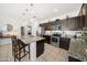 Modern kitchen featuring granite countertops, stainless steel appliances, and dark wood cabinets at 23690 W Ripple Rd, Buckeye, AZ 85326