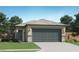Charming single-story home with a two-car garage, complemented by lush green grass and desert landscaping at 25109 N 174Th Ln, Surprise, AZ 85387