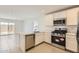 Well-lit kitchen featuring stainless steel appliances, white cabinets, and sliding glass doors in adjacent dining area at 25109 N 174Th Ln, Surprise, AZ 85387