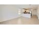 Open-concept living space with tile flooring flowing into kitchen with breakfast bar at 25109 N 174Th Ln, Surprise, AZ 85387