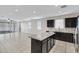 Open-concept kitchen with a granite island, dark cabinets, and stainless steel appliances at 29402 W Mitchell Ave, Buckeye, AZ 85396