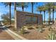 Community sign featuring stone accents, flowers, and landscaping at 29402 W Mitchell Ave, Buckeye, AZ 85396