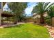 Lush backyard featuring a patio, brick walkway, green grass, trees and a palm tree at 3337 E Glade Cir, Mesa, AZ 85204