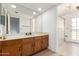 Bright bathroom featuring a wooden vanity, large mirror, and shower at 3337 E Glade Cir, Mesa, AZ 85204