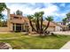 Charming two-story home features a red tile roof, two-car garage and mature palm trees at 3337 E Glade Cir, Mesa, AZ 85204