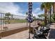 Backyard patio features a fire pit, umbrella, and seating while overlooking the manicured golf course and lake at 3441 N 162Nd Ln, Goodyear, AZ 85395
