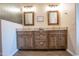 Bathroom vanity with double sinks, granite countertops, wood cabinets, and framed mirrors with adjacent semi-frosted privacy glass at 3441 N 162Nd Ln, Goodyear, AZ 85395