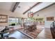 Bright dining room with vaulted ceilings and beam accents offers views of the backyard and patio area with desert landscaping at 3441 N 162Nd Ln, Goodyear, AZ 85395