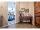Welcoming entryway with beautiful wood floors and decorative console table with a view to the bedroom at 3441 N 162Nd Ln, Goodyear, AZ 85395