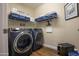 Laundry room featuring a modern washer and dryer set with storage shelves, and clean space at 3441 N 162Nd Ln, Goodyear, AZ 85395