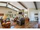 Cozy living room featuring a stone fireplace, beamed ceilings, and comfortable seating at 3441 N 162Nd Ln, Goodyear, AZ 85395