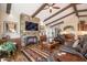 Inviting living room with stone fireplace, wood beams, and stylish southwestern rug at 3441 N 162Nd Ln, Goodyear, AZ 85395