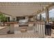 Outdoor kitchen boasts a built-in grill, sink, and counter space beneath a modern pergola at 3441 N 162Nd Ln, Goodyear, AZ 85395