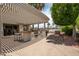 Outdoor kitchen and bar area with built-in grill, sink and barstools under a pergola-covered patio at 3441 N 162Nd Ln, Goodyear, AZ 85395