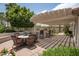 Entertaining patio with a dining table and outdoor kitchen area under a slatted pergola for shade at 3441 N 162Nd Ln, Goodyear, AZ 85395