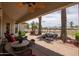 Covered patio featuring a seating area and water feature with views of the golf course and serene pond at 3441 N 162Nd Ln, Goodyear, AZ 85395