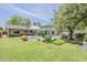 Expansive backyard with lush lawn, sparkling pool, patio area, and mature trees at 402 E Claremont St, Phoenix, AZ 85012
