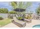 Lush backyard offers a relaxing space with chaise lounges and an umbrella for shade by the pool at 402 E Claremont St, Phoenix, AZ 85012