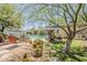 Lush backyard featuring a sparkling pool, mature trees, and comfortable seating area at 402 E Claremont St, Phoenix, AZ 85012