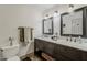 Bathroom with double vanity, marble countertop, dark wood cabinets, and modern fixtures at 402 E Claremont St, Phoenix, AZ 85012