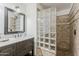 Bathroom featuring elegant vanity with marble top, dark wood cabinets, and glass block shower at 402 E Claremont St, Phoenix, AZ 85012