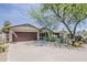 Single story home with a brick exterior, well-kept lawn, mature trees, and desert landscaping at 402 E Claremont St, Phoenix, AZ 85012