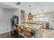 Kitchen with granite island and bar seating, stainless appliances, and stone tile floors at 402 E Claremont St, Phoenix, AZ 85012
